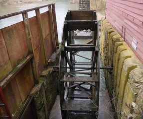 Close up, top view of a functioning waterwheel beside a river in Arkansas