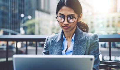 Attractive young businesswoman using tablet on terrace