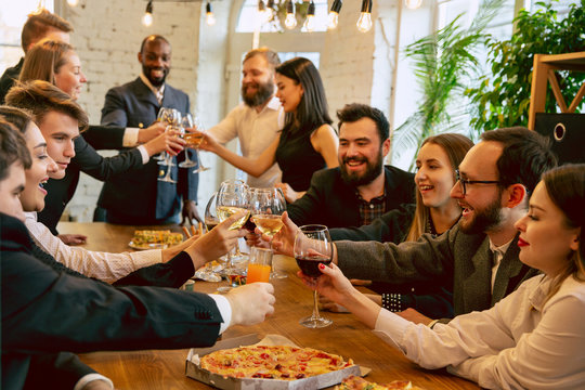 Happy Co-workers Celebrating While Company Party And Corporate Event. Young Caucasian People In Business Attire Cheering, Laughting. Concept Of Office Culture, Teamwork, Friendship, Holidays, Weekend.