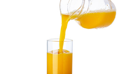 Orange juice pouring from pitcher into glass isolated on white background