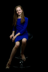 Obraz na płótnie Canvas A teenage girl is sitting on a chair.