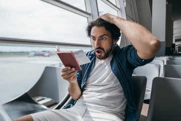 The man is very upset in the waiting room at the gate to the airport.