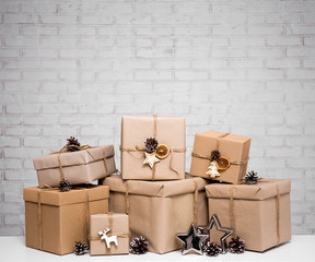 close up of beige gift boxes and copy space over white brick wall