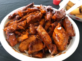 Top shot of rice serving topped with chicken barbeque and sauce