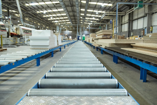An empty industrial roller conveyor belt in a fully automated factory. roller conveyor to easily move heavy industrial goods around without the need for humans.future of industrial manufacture.