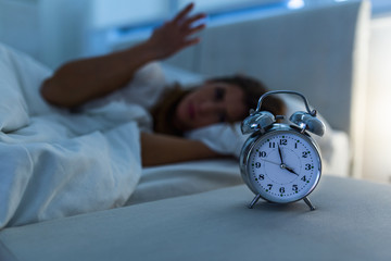 Woman lying in bed suffering from insomnia, Sleepless and desperate beautiful caucasian woman awake at night not able to sleep, feeling frustrated and worried suffering from insomnia in sleep disorder - obrazy, fototapety, plakaty