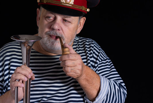 Portrait Retired Senior Man Taking Trumpet And Tobacco Pipe In Darkness