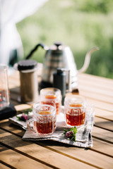 Delicious fresh three cups of filter aeropressed coffee outdoors at the picnic on the rustic wooden table