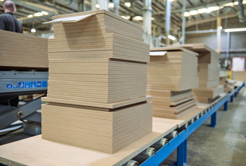 chipboard on an industrial roller conveyor belt in a fully automated factory. roller conveyor to easily move heavy industrial goods around without the need for humans.future of industrial manufacture.