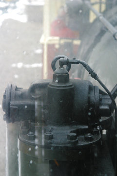 Steam locomotive details on a rainy, snowy day