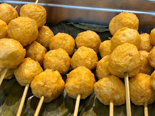 Fish balls on sticks placed on a banana leaf. Fishballs are popular streetfoods in the Philippines