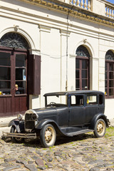 Black and obsolete car on one of the cobblestone streets, in the city of Colonia del Sacramento, Uruguay. It is one of the oldest cities in Uruguay.