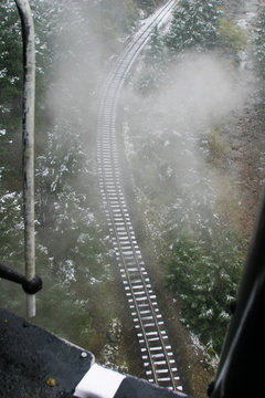 Stem locomotive and rail tracks on a rainy, snowy day