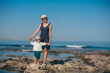 Mom with a little son on a trip near the sea.
