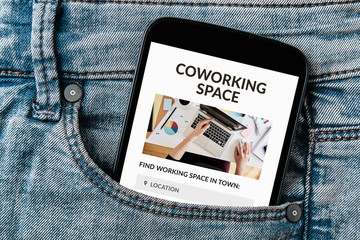 Coworking space concept on smartphone screen in jeans pocket