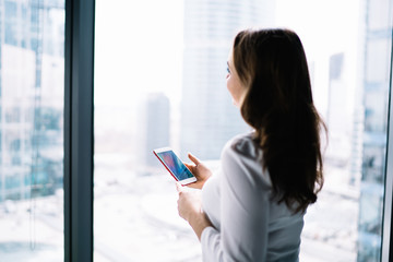 Fototapeta premium Female using modern smartphone at workplace