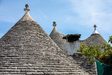 Fototapeta na wymiar Stone roofs of Trulli Houses in Alberobello; Italy. The style of construction is specific to the Murge area of the Italian region of Apulia (in Italian Puglia). Made of limestone and keystone.