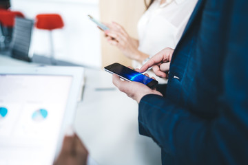 Side view of male office worker using smartphone