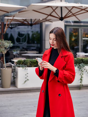 Pretty shy unsurpassed brunette girl with a phone in her hands