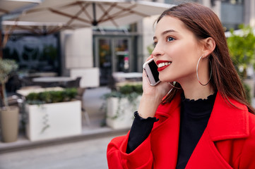 Shy cute unsurpassed lady talking on gray mobile phone and smiling