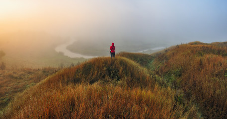 Obraz premium tourist on the rock. a traveler alone with nature. woman enjoys the view