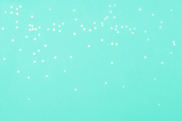 White stars on mint backdrop. Festive concept. Flat lay style.