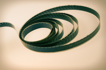 old black and white 16mm film wrapped in rings lies on a light background.