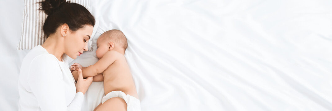 Young mom sleeping with her baby, panorama with empty space