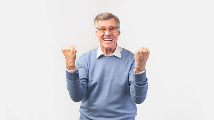 Excited Senior Man Shaking Fists Standing Over White Background