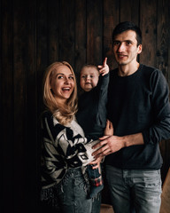 Portrait of Family Mom Dad with One Little Kid Playing in Room Decorated in Christmas Theme