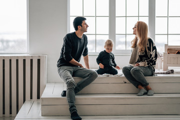 Portrait of Family Mom Dad with One Little Kid Playing in Room Decorated in Christmas Theme