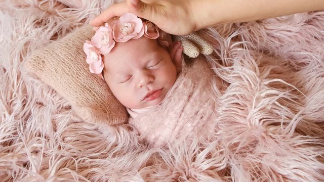 Mother touching newborn girl with beatiful floral headband