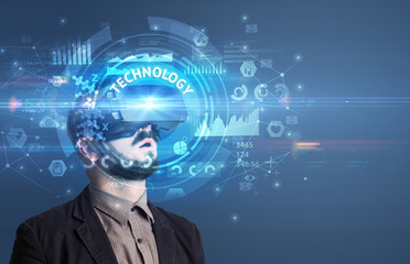 Businessman looking through Virtual Reality glasses with TECHNOLOGY inscription, innovative technology concept