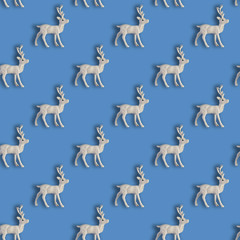 Seamless Christmas pattern with Xmas white deer on blue background.
