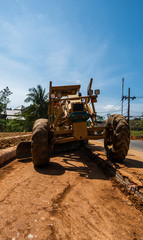 Grader is working on road construction. Grader industrial machine on construction of new roads. Heavy duty machinery working on highway. Construction equipment. Compaction of the road.