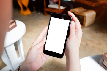 Mockup picture of business woman’s hands holding smart phone with white blank screen in modern place.