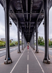 Woman walking under the Bir-Hakeim metro bridge in Paris
