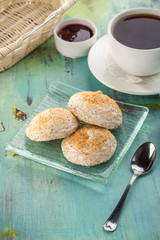 almond and meringue biscuits and cup of black tea on blue wooden table