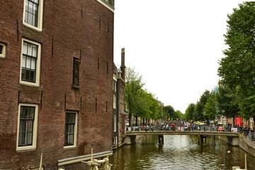 Amsterdam, Netherlands. August 2019. Typical view of the historic center: bridges over the canals are chosen by tourists to take a break to observe the particular landscape.