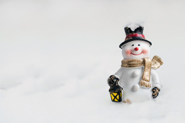 Beautiful christmas snowman toy standing on snow.