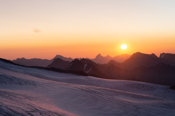 beautiful sunrise in the mountains. Golden hour photography, the rising sun behind the mountains. Yellow and pink color. Mount Elbrus. Russia. The Caucasus. Panorama of mountains at sunrise.