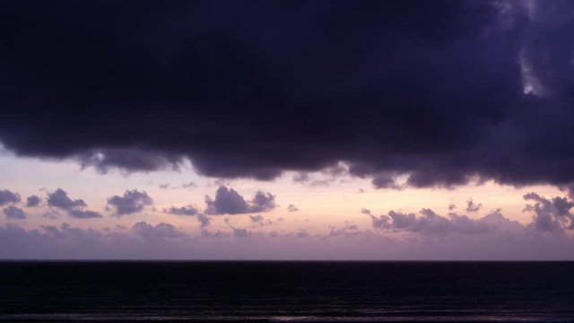 Stock 4k: Time lapse, timelapse of sunrise sky on the beach. Royalty high-quality free stock time lapse footage of sun rays emerging though the dark storm clouds background. Dramatic sunset sky cloud