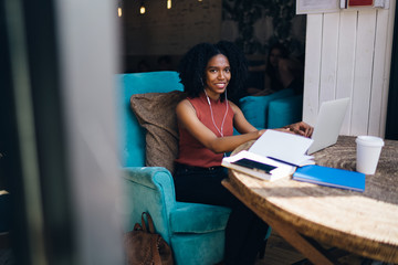 Black lady surfing on laptop in cafe