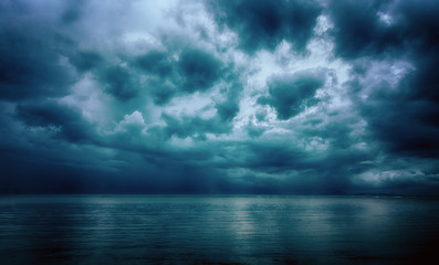 Dramatic stormy dark cloudy sky over sea, natural photo background