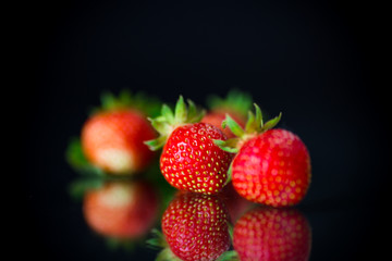 ripe red strawberries on a black background