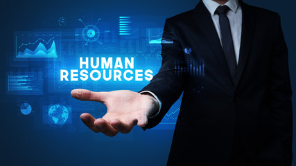 Hand of Businessman holding HUMAN RESOURCES inscription, business success concept