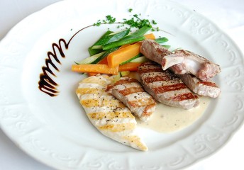 mix of grilled meat and vegetables on the white plate