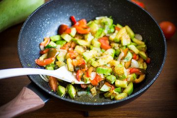 fried zucchini with red pepper, onions, tomatoes and other vegetables