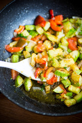 fried zucchini with red pepper, onions, tomatoes and other vegetables