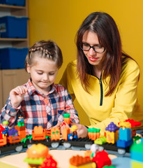Fototapeta premium Zabawki edukacyjne dla dzieci w wieku przedszkolnym i przedszkolnym. Dziecko bawi się blokami konstruktora w klasie.